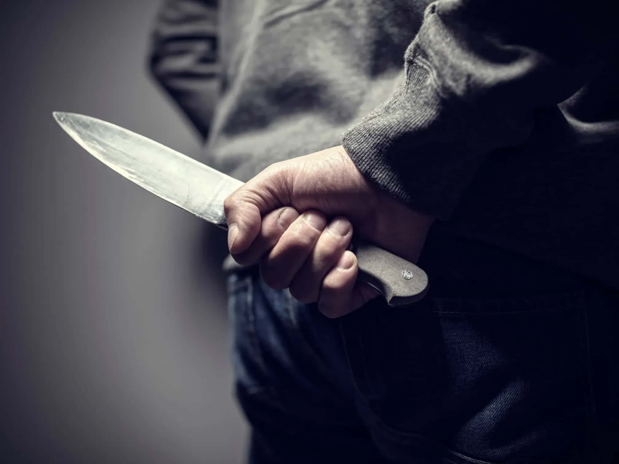 Messer als Waffe hinter Rücken