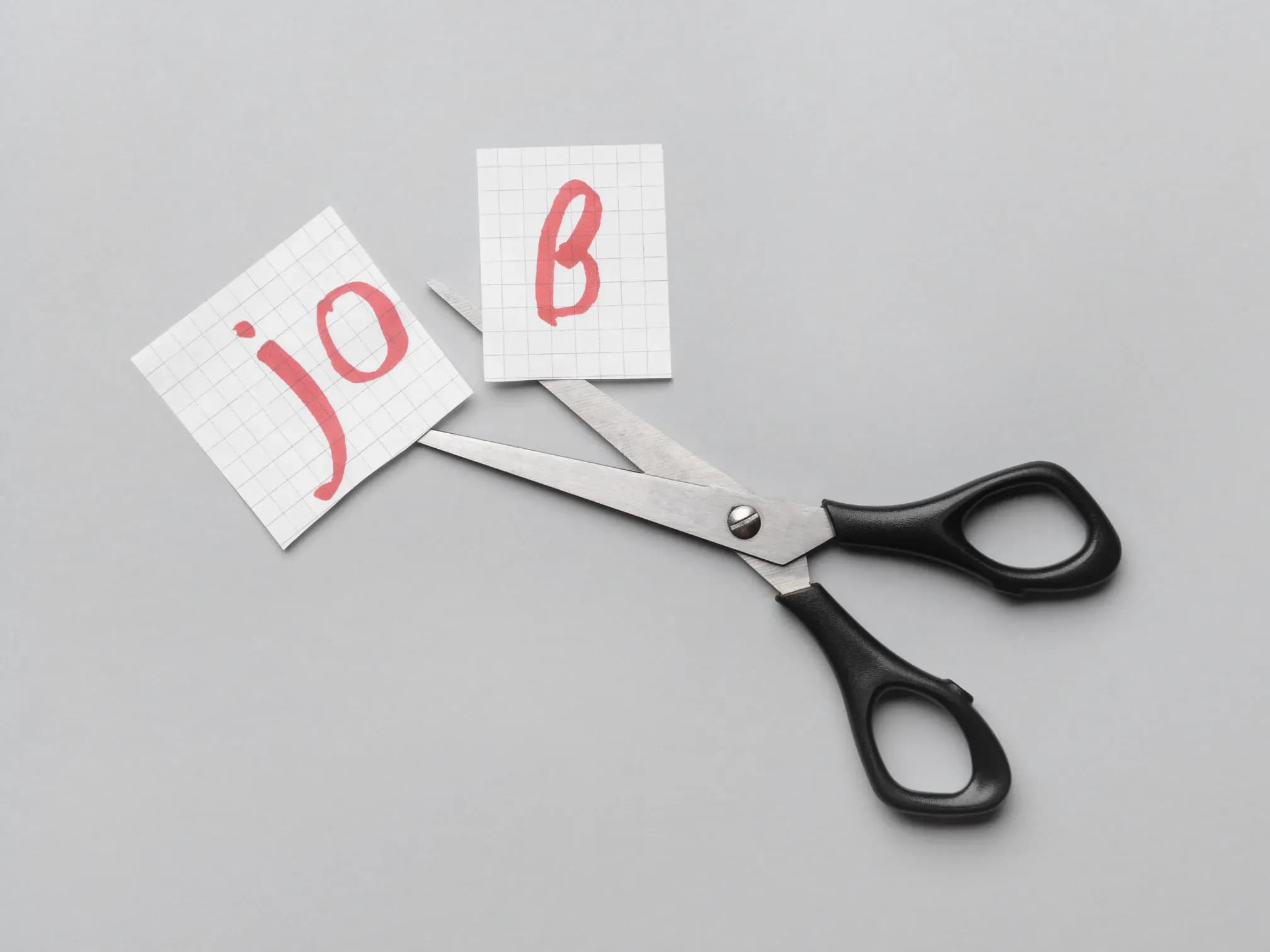 Schere zerschneidet Schild mit Aufschrift Job