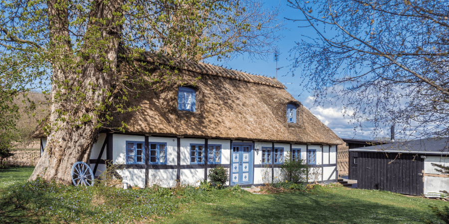 Hier ist ein Ferienhaus mit Reetdach zu sehen.