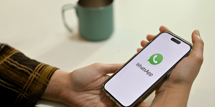 Handy mit WhatsApp-Logo in der Hand