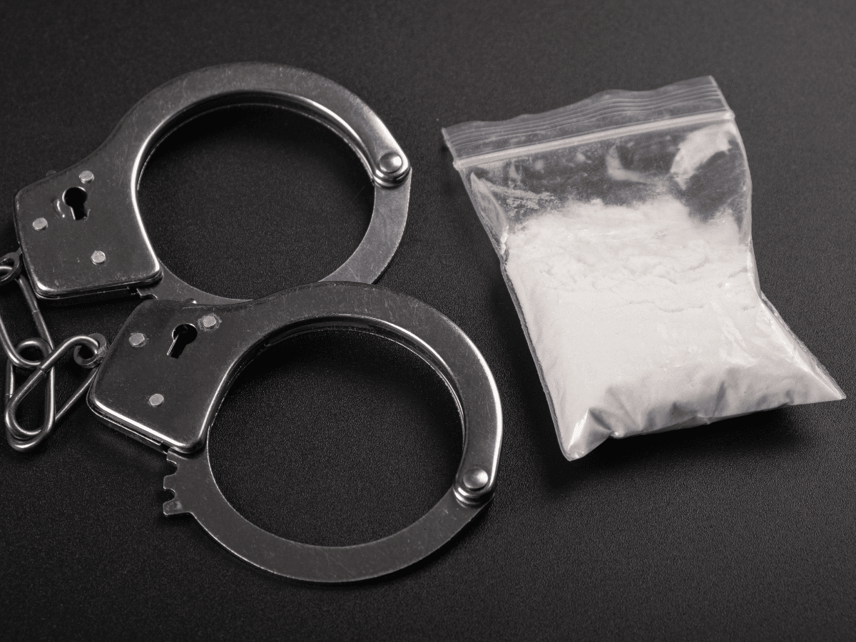Das Bild zeigt Handschellen und ein Päckchen Kokain