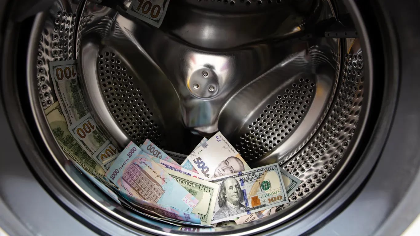 Geld wird in Waschmaschine gewaschen als Symbol für Geldwäsche
