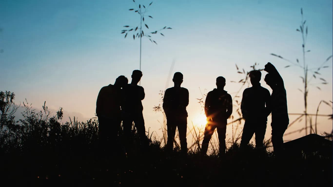 Jugendliche stehen im Sonnenuntergang