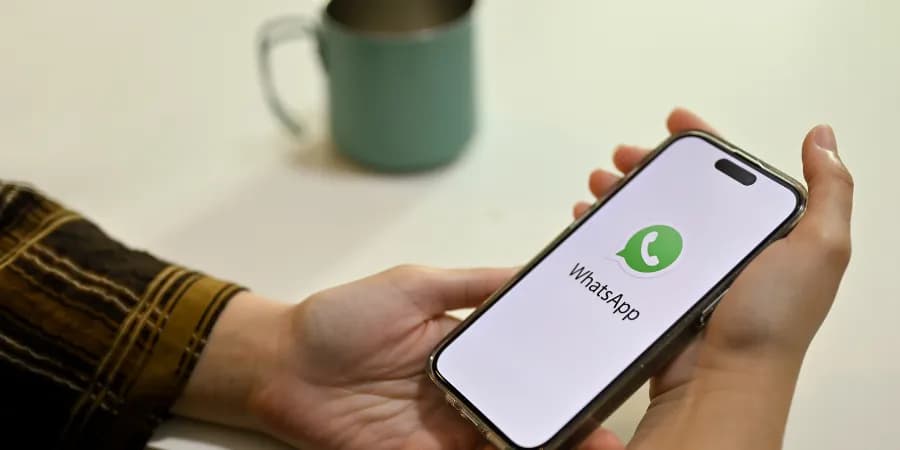 Handy mit WhatsApp-Logo in der Hand